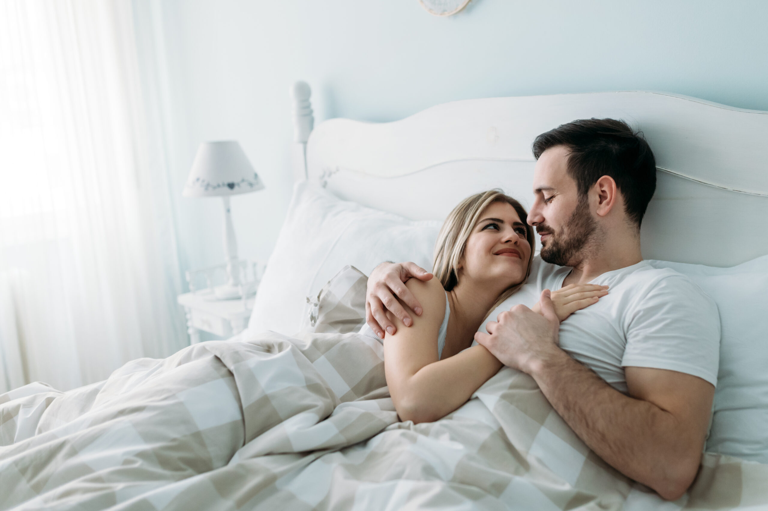 Portrait of young loving couple in bedroom